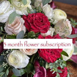 Bouquet of red, white, and blush roses with pink calla lilies