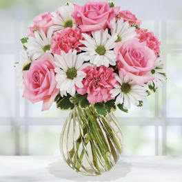 Pink roses and white daisies in a clear glass vase
