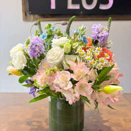 Mixed bouquet of pink alstroemeria, white roses, and yellow tulips in a clear glass cylinder vase