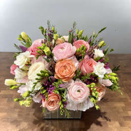 Pink and peach mixed flower arrangement in a glass vase