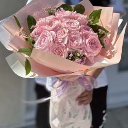Pink rose bouquet wrapped in pastel paper with a lavender ribbon
