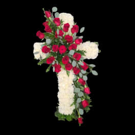 Cross-shaped floral tribute with red roses and white flowers