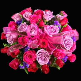 Bouquet of pink and red roses with a pink ribbon bow