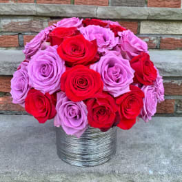 Bouquet of red and lavender roses in a silver vase