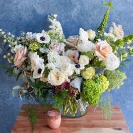 Mixed bouquet of white and blush flowers in a glass vase