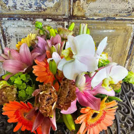 Mixed bouquet with white orchids, pink lilies, and orange gerbera daisies