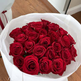 Bouquet of red roses wrapped in white paper