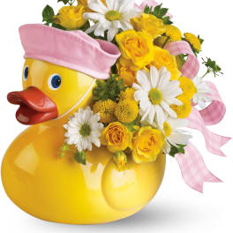 Yellow duck planter with yellow roses, white daisies, and pink ribbon