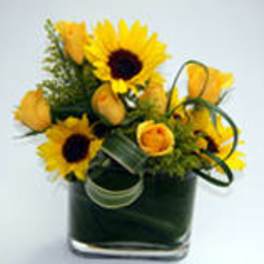 Sunflowers and yellow roses in a square glass vase