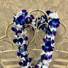 Blue and white flower lei draped over a metal chair