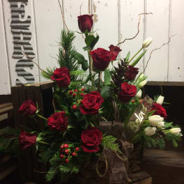 Red roses and white tulips arranged in a rustic basket