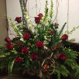 Red roses and white snapdragons in a rustic holiday arrangement
