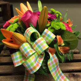 Bright mixed bouquet with lilies, roses, and a plaid ribbon bow