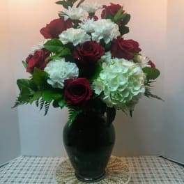 Red roses and white carnations arranged in a dark vase