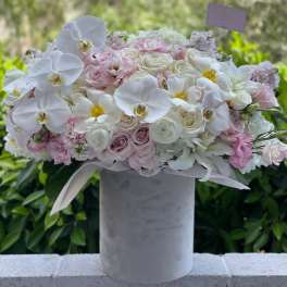 Pink and white floral arrangement in a tall gray vase