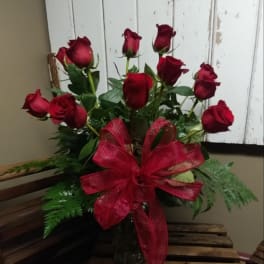 Bouquet of red roses with a large red ribbon in a glass vase