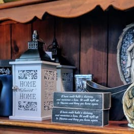 Shelf of memorial plaques, lanterns, and angel figurines