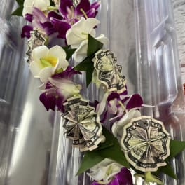 Purple and white orchid lei with folded dollar bills