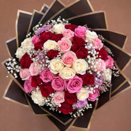 Large bouquet of pink, red, and white roses with purple accents