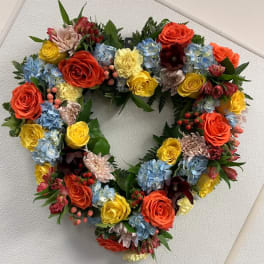Heart-shaped floral wreath with multicolored roses and hydrangeas