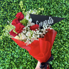 Bouquet of red roses and white flowers with a congratulatory card