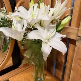 White lilies arranged in a clear glass vase