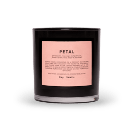 Black scented candle in a glass jar with a pink label