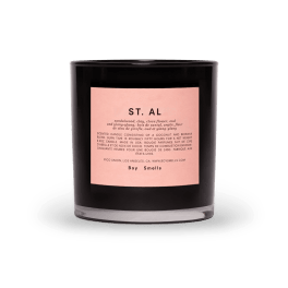 Black scented candle in a glass jar with a pink label