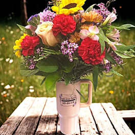 Mixed bouquet in a pink handled tumbler with sunflowers and carnations