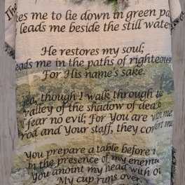 Floral arrangement on a Psalm-printed blanket hanging on a wooden wall