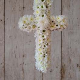 White daisy cross arrangement on a rustic wood background