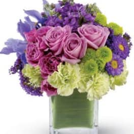 Pink and purple bouquet in a clear square vase