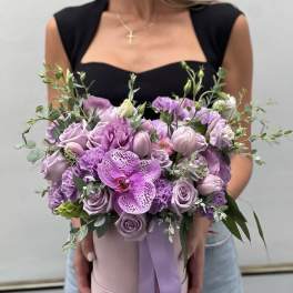 Lavender bouquet with roses, carnations, and an orchid in a pink hat box