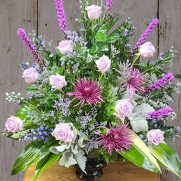 Lavender roses and purple flowers in a black vase