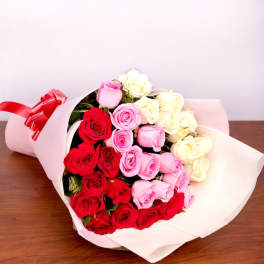 Bouquet of red, pink, and white roses wrapped in pale paper