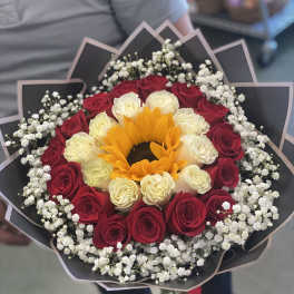 Bouquet of red and white roses with a sunflower center