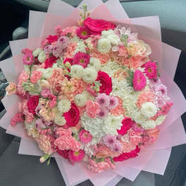 Large pink and white mixed bouquet wrapped in translucent paper