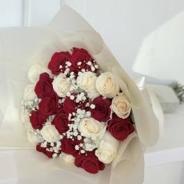 Bouquet of red and white roses wrapped in cream paper