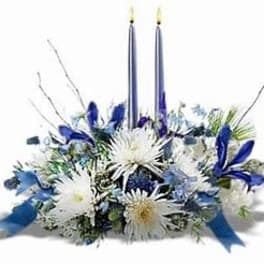 Blue and white floral centerpiece with two tall candles
