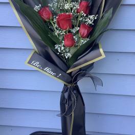 Bouquet of red roses with baby's breath in black and gold wrap