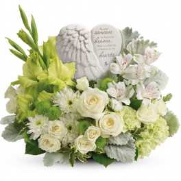 White and green sympathy arrangement with roses and lilies around a memorial plaque