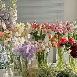 Assorted pastel flower bouquets in glass vases on a table