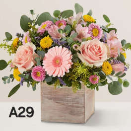 Pink and yellow mixed flower arrangement in a wooden box