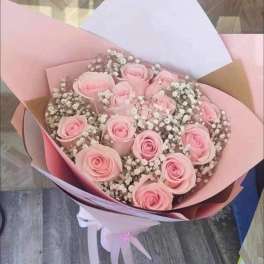 Bouquet of pale pink roses with baby's breath in pastel wrapping