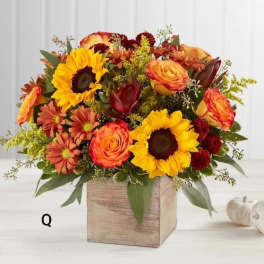 Mixed bouquet of sunflowers, roses, and mums in a wooden box