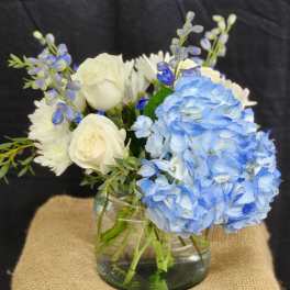 Blue hydrangeas and white roses in a glass vase