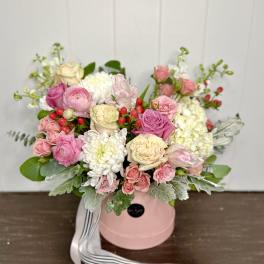 Pink and white rose bouquet in a pink hat box with ribbon.