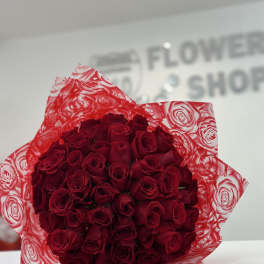Bouquet of red roses wrapped in red patterned paper
