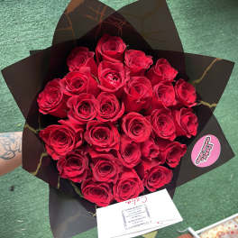 Bouquet of red roses wrapped in black paper