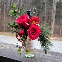 Pink roses and a red daisy in a wine bottle vase